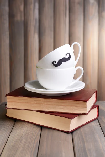 Cup with mustache on table on wooden background — Stock Photo, Image