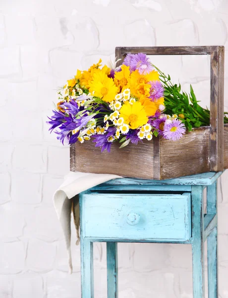 Красивые цветы в ящике на деревянном подставке на светлом фоне — стоковое фото
