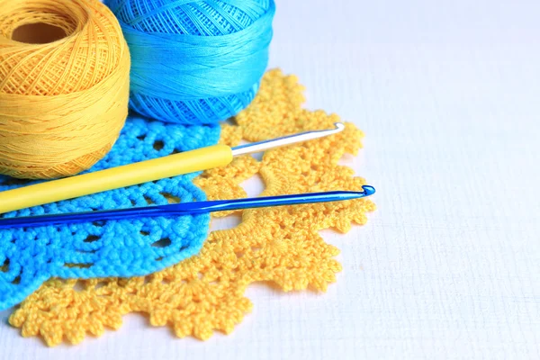 Colorful clews and crochet hooks on light background — Stock Photo, Image