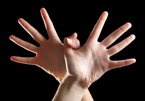 Ludzkie ręce na czarnym tle — Zdjęcie stockowe