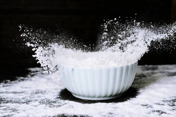 Mehl in Schüssel auf Tisch auf Holzgrund — Stockfoto