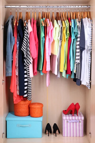 Colorful clothes hanging in wardrobe — Stock Photo, Image