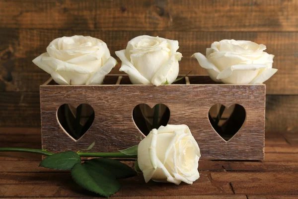 Hermosas rosas blancas en caja decorativa sobre mesa de madera — Foto de Stock