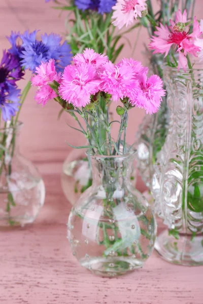 Vackra sommarblommor i vaser på rosa trä bakgrund — Stockfoto