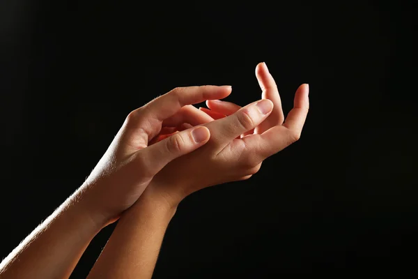 Ludzkie ręce na czarnym tle — Zdjęcie stockowe