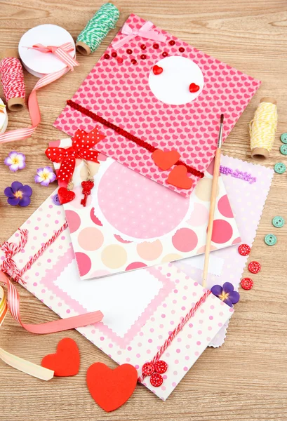 Mooie handgemaakte postkaarten en scrapbooking elementen, op houten tafel — Stockfoto