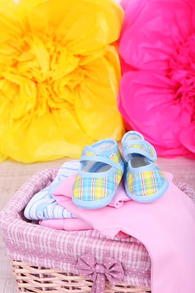 Baby clothes in basket on floor in room — Stock Photo, Image