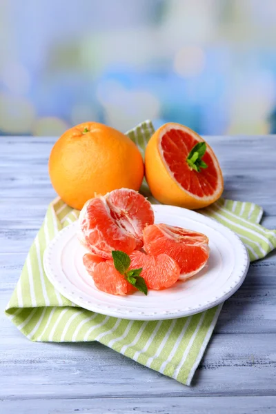 Rijp gepelde grapefruits op plaat, op de houten tafel kleur op lichte achtergrond — Stockfoto
