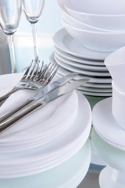 Set of white dishes on table on light background — Stock Photo, Image