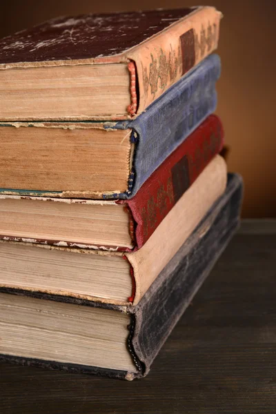 Livros antigos na mesa sobre fundo marrom — Fotografia de Stock