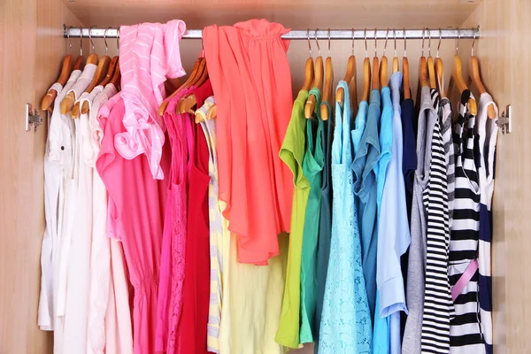 Female clothes on hangers in wardrobe — Stockfoto