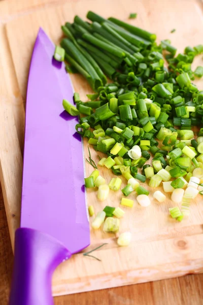 Cipolla verde tritata con coltello sul tagliere — Foto Stock