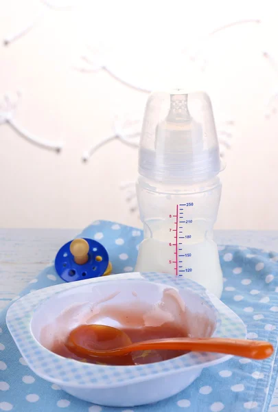 Comida para bebés y leche en la mesa sobre fondo claro — Foto de Stock