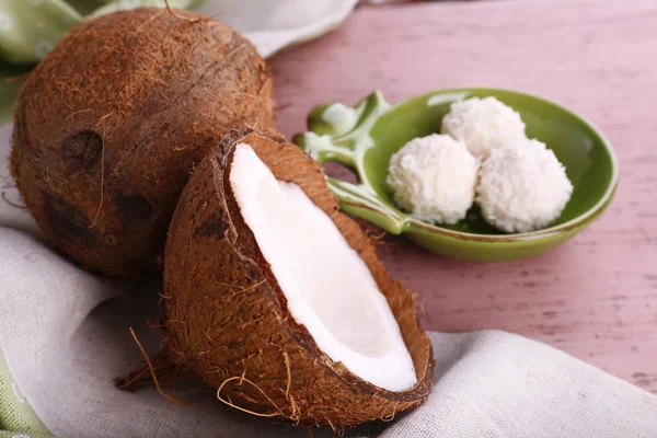 Сломанный кокос с леденцами на деревянном фоне — стоковое фото