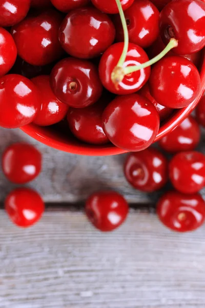 Cerezas dulces en taza sobre fondo de madera — Foto de Stock