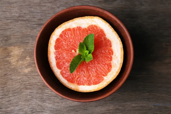 Teil reife Grapefruit in Schale, auf Holzgrund — Stockfoto