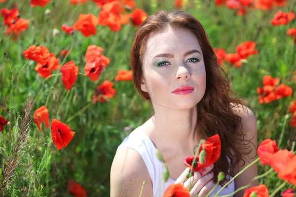 Beautiful young woman in poppy field — Stock Photo, Image