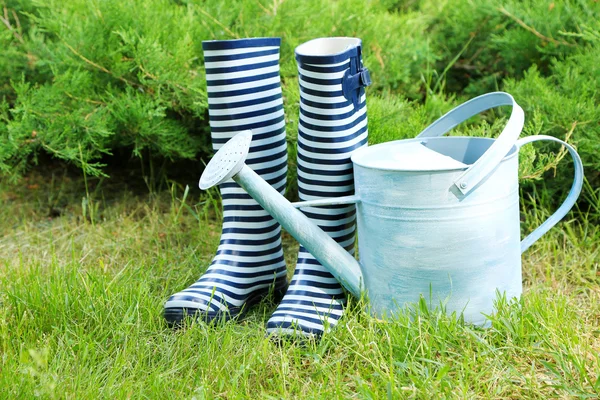 Gummistiefel mit Gießkanne auf Gras - Gartenkonzept — Stockfoto