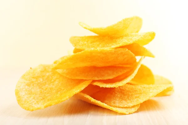 Heap of homemade potato chips on light background — Stock Photo, Image