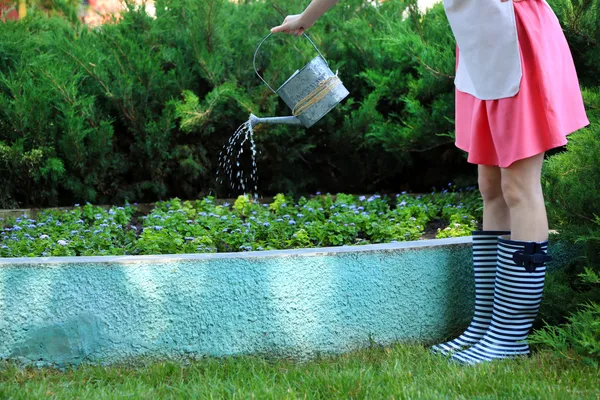 Young woman in rubber boots holding watering can, outdoors — Stock Photo, Image