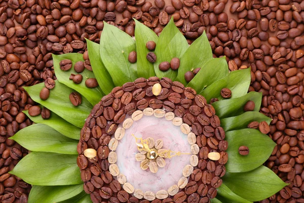 Kahve çekirdekleri, kahverengi zemin üzerine güzel bir saat — Stok fotoğraf