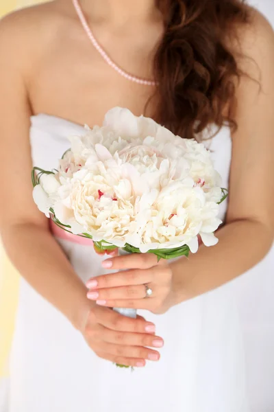 Bride holding wedding bouquet of white peonies, close-up, on light background — Stock Photo, Image