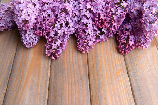 Schöne lila Blumen auf hölzernem Hintergrund — Stockfoto