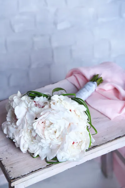 Beautiful wedding bouquet on   wooden ladder on light wall background — Stock Photo, Image