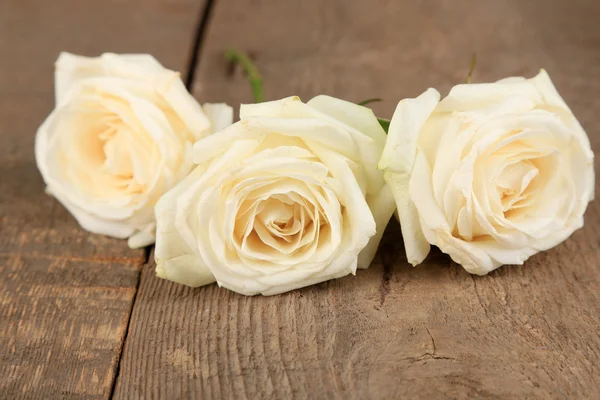 Schöne weiße Rosen auf Holztisch — Stockfoto