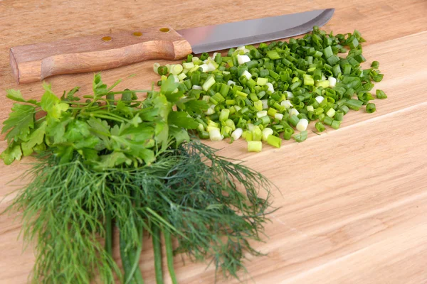 Cebola verde picada com faca na placa de corte — Fotografia de Stock