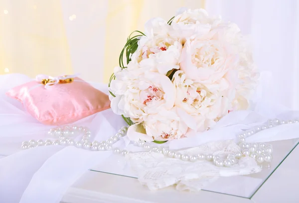 Krásné svatební kytice a dekorativní polštář pro snubní prsteny na židli na světlé pozadí — Stock fotografie