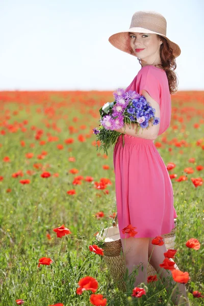 Bella giovane donna in possesso di borsa di vimini nel campo di papavero — Foto Stock