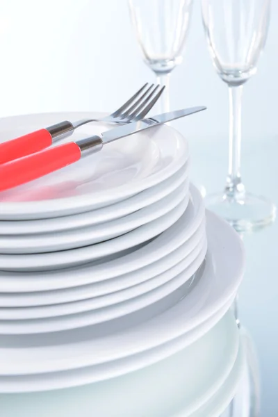 Set di piatti bianchi sul tavolo su sfondo chiaro — Foto Stock