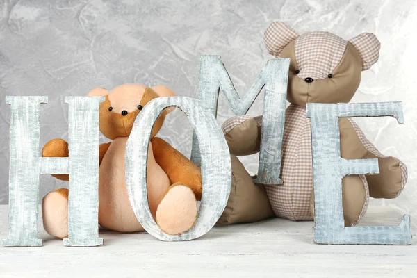 Decoratieve brieven vormen woord huis met teddy bear op grijze achtergrond — Stockfoto