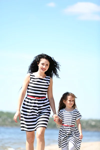 Happy mom and daughter. Walk on the beach — Stock fotografie