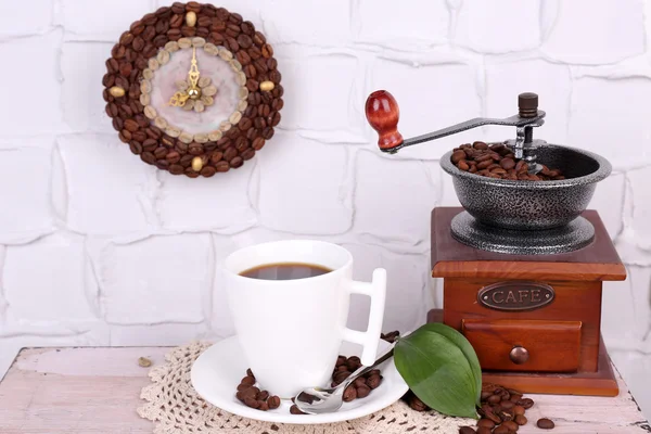 Nature morte tasse de café et horloge, sur fond de mur gris — Photo