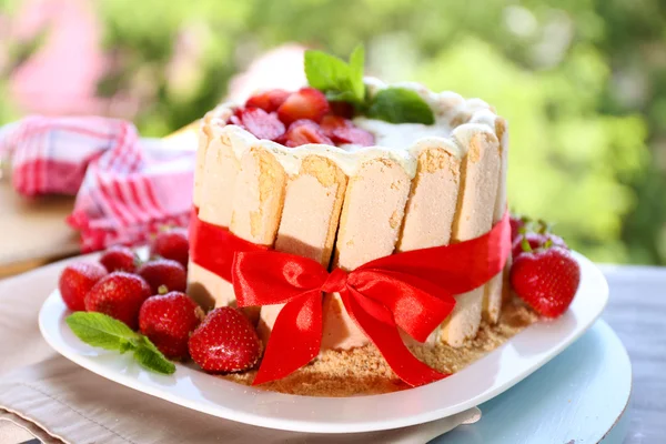 Leckere Torte Charlotte mit frischen Erdbeeren auf grünem Naturhintergrund — Stockfoto