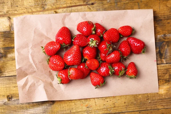 成熟的甜草莓在纸巾上彩色木背景 — 图库照片