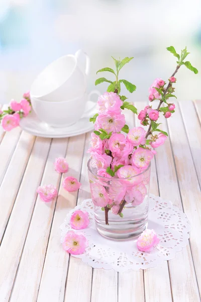 Mooie fruit blossom in glas op tafel op lichte achtergrond — Stockfoto