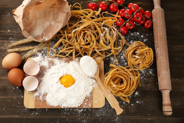 Nature morte avec des pâtes maison crues et des ingrédients pour les pâtes — Photo