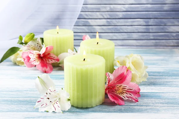 Hermosas velas con flores sobre fondo de madera — Foto de Stock