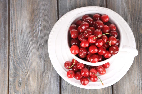 Sweet cherries in mug on wooden background — Stock Photo, Image