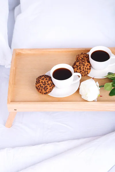 Чашки кофе на удобной мягкой кровати с подушками — стоковое фото