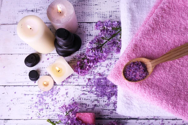 Composição com tratamento de spa, toalhas e flores lilás, sobre fundo claro — Fotografia de Stock