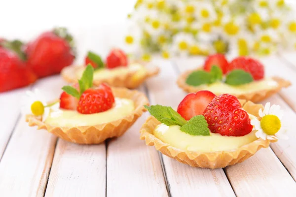 Smakelijke tartlets met aardbeien op tabel close-up — Stockfoto