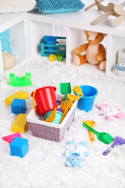 Brinquedos coloridos no tapete fofo na sala de crianças — Fotografia de Stock