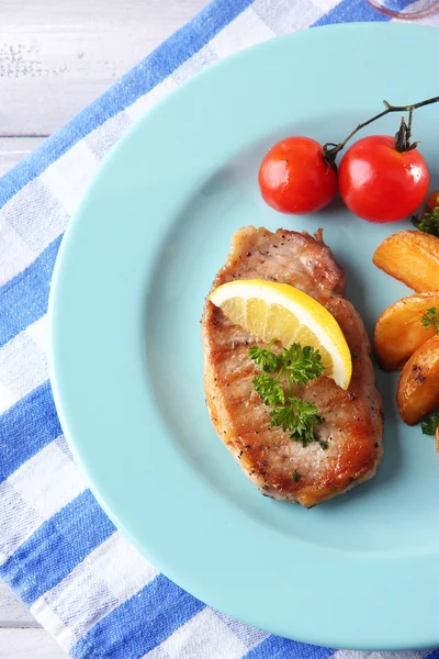 Gegrilde biefstuk, gegrilde groenten en gebakken aardappel stukken op tafel, op lichte achtergrond — Stockfoto