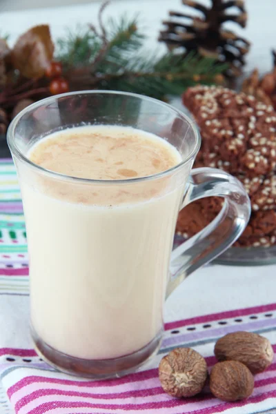 Cup of eggnog with cookie and fir branches on table close up — Stock Photo, Image