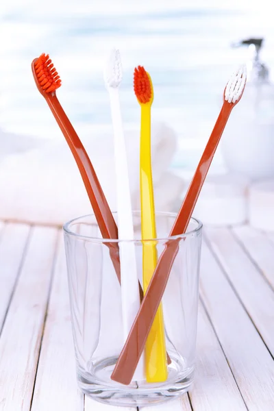 Tandenborstels in glas op een lichte ondergrond — Stockfoto