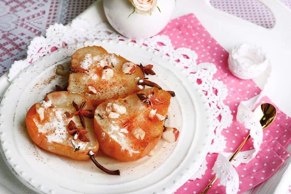 Bakade päron med sirap på plattan, färg trä bakgrund — Stockfoto